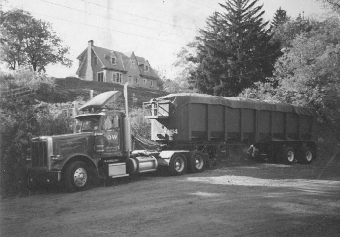 An early DW tractor with tarped trailers, from the company&rsquo;s first years